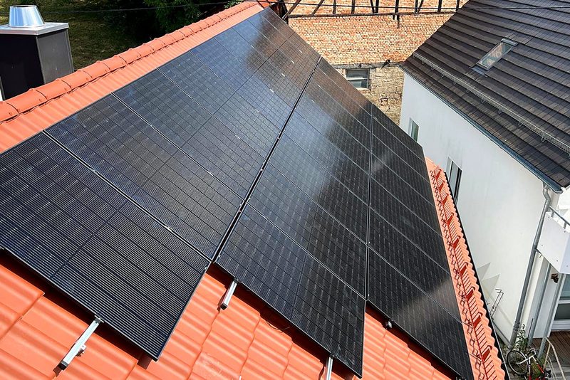 Photovoltaikanlage: schwarze Module auf einem Ziegeldach, sauber in Reihen montiert