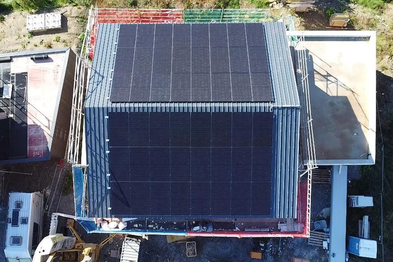 Neubau mit Blechdach, beide Dachseiten mit Modulen belegt