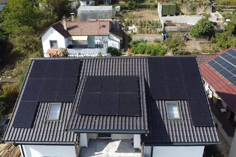 Satteldach aus anthrazitfarbenen Ziegeln, Module um zwei Dachfenster gesetzt